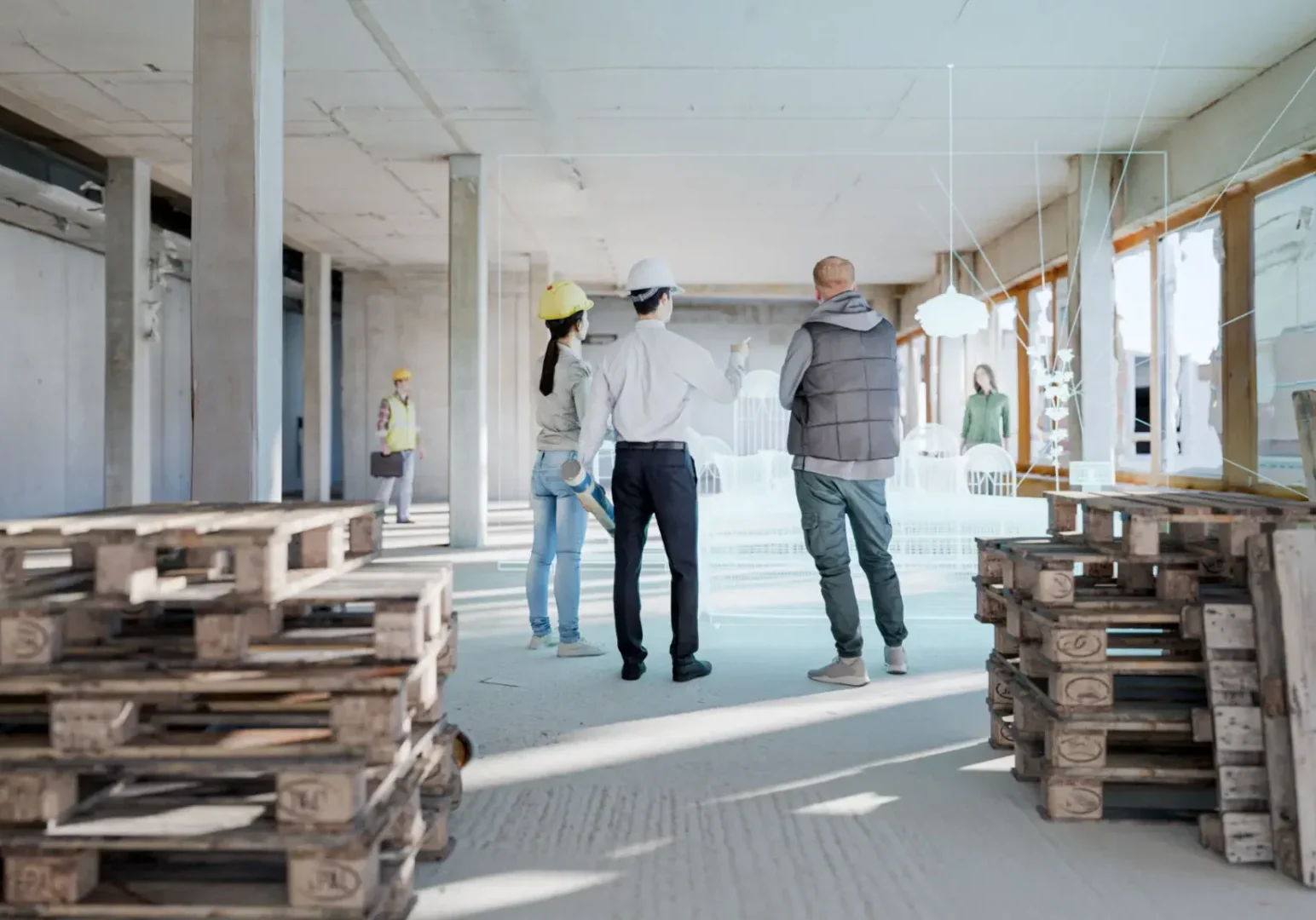 Two men discussing building plans inside an unfinished construction site.